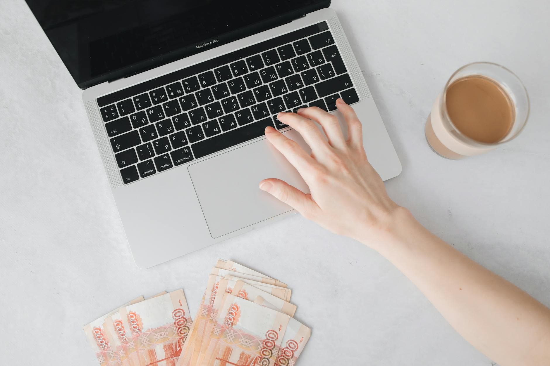 A person smiling while typing on a laptop in a comfortable home office setting, representing achieving their first online job fast.